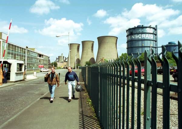 Two men walk through the gates of Ravenscraig after the last shift before the plant closed in June 1992